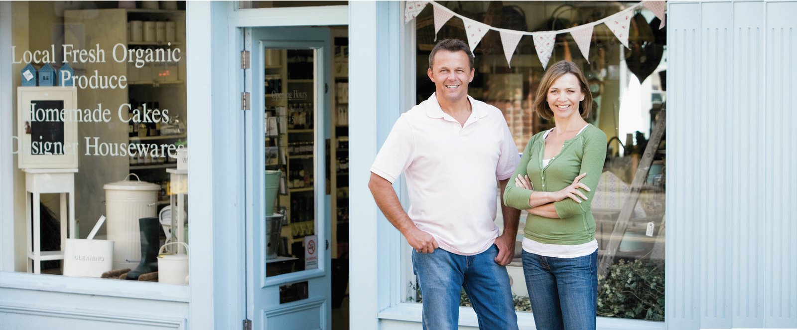 two business owners standing in front of their store