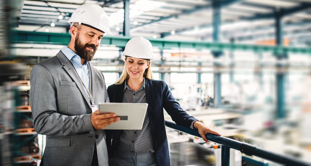 Business people in a warehouse looking at tablet