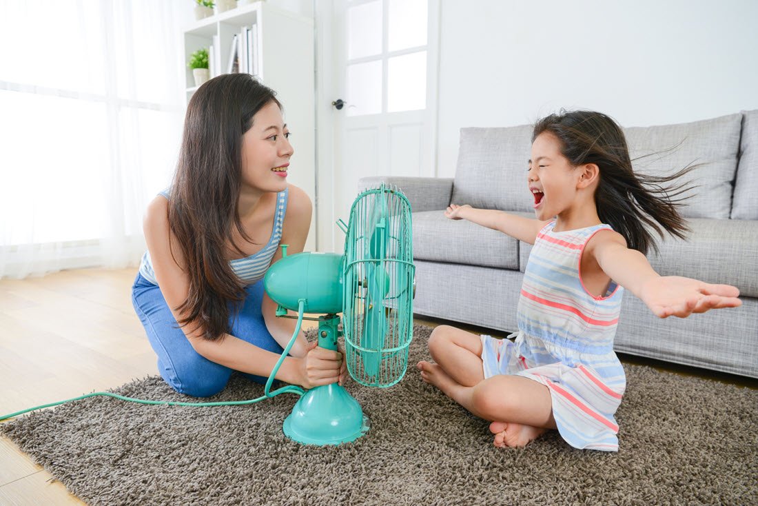 Adult and child with electric fan