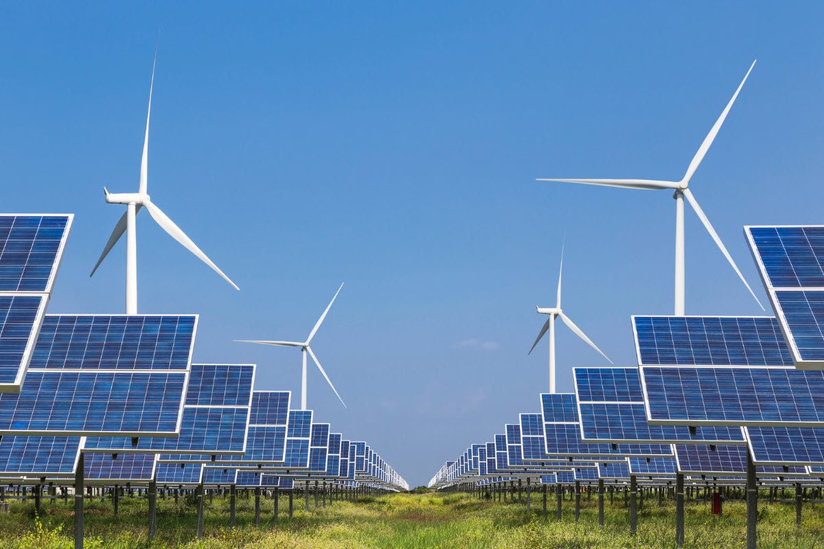 Solar farm with wind turbines in the background