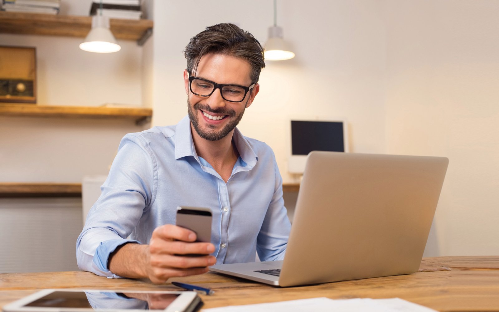 Man at computer with phone