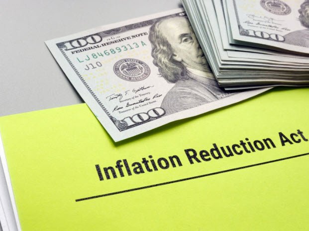 hundred dollar bills on a piece of paper that says Inflation Reduction Act