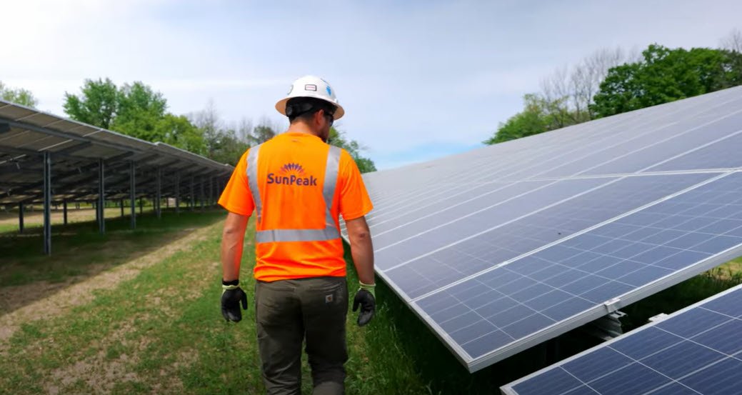 man walking next to solar panels